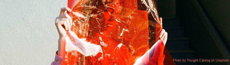 volto di donna coperto da foglio rosso trasparente (da unsplash.com)