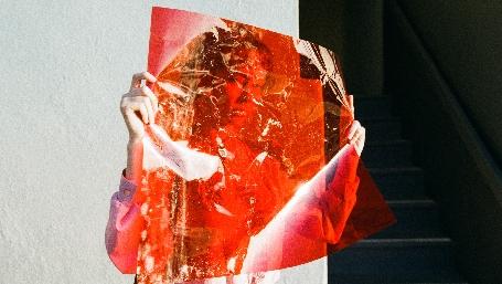 donna dietro ad un lucido rosso trasparente (photo by unsplash.com)